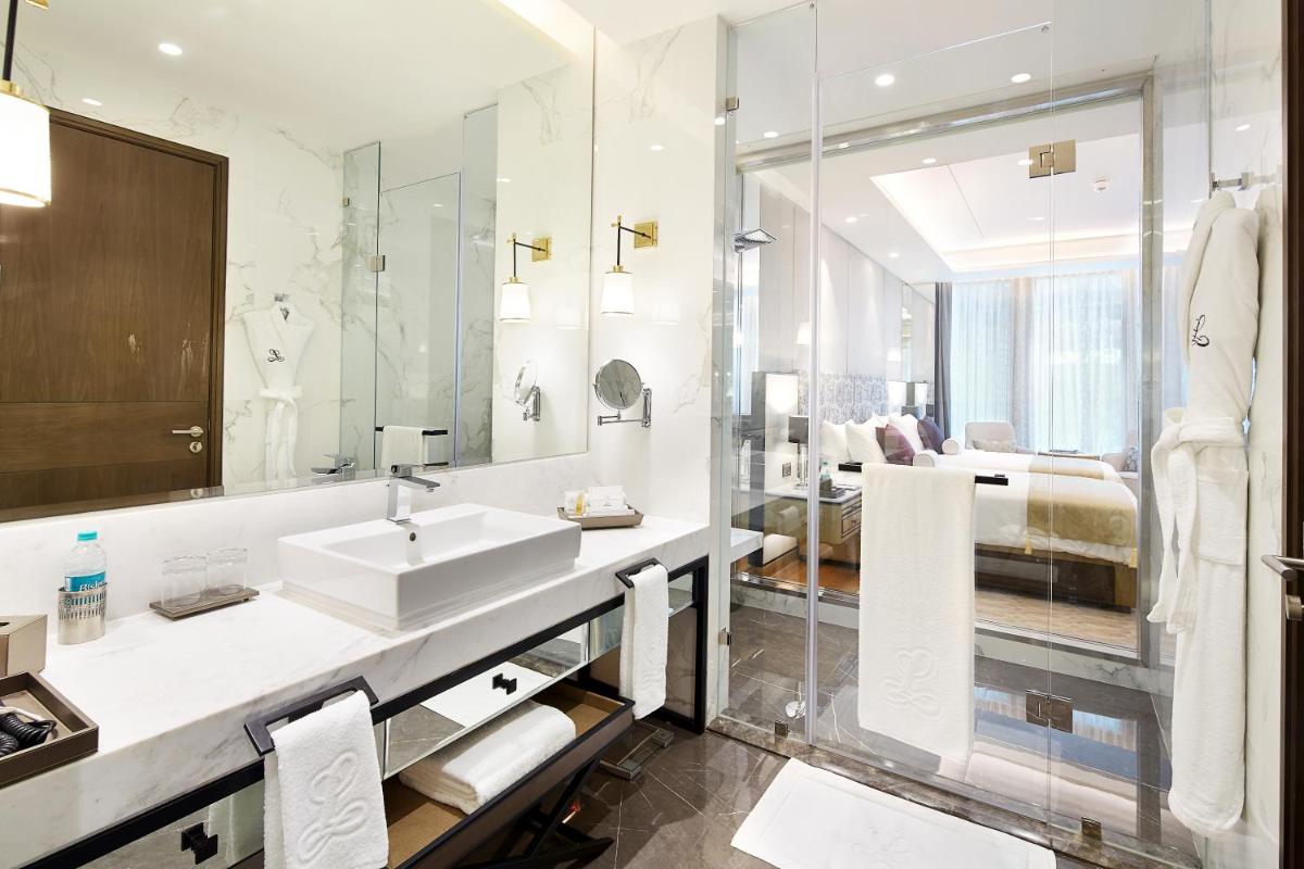 a bathroom with a sink and a mirror at The Leela Bhartiya City Bengaluru in Bengaluru a bathroom with a sink and a mirror at The Leela Bhartiya City Bengaluru in Bengaluru