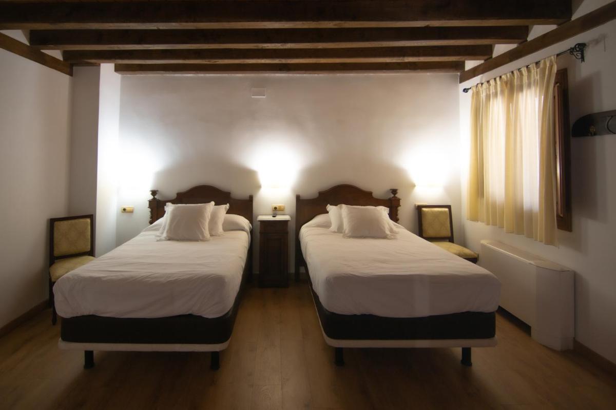 Cama o camas de una habitación en Hospedium Hotel Rural Abadía de Yuste