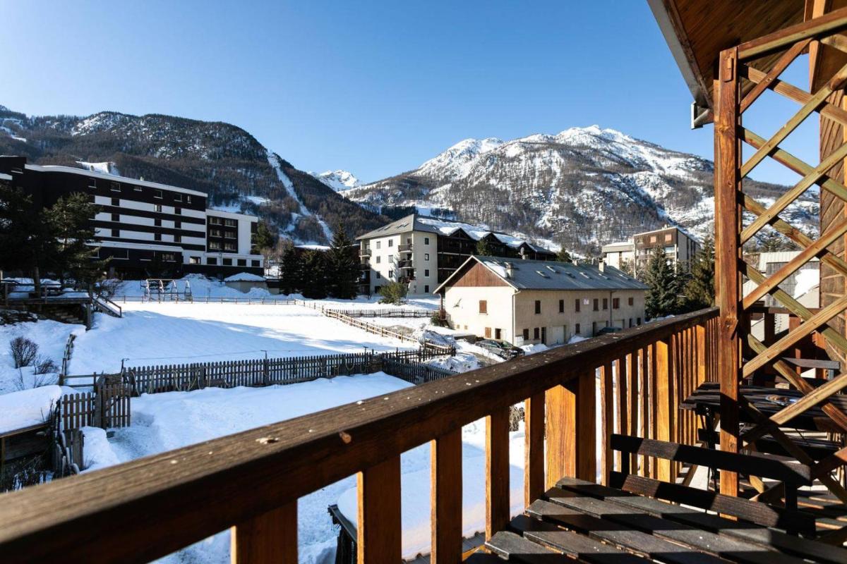vue depuis un balcon d'une ville aux montagnes enneigées dans l'établissement Hôtel Mont Thabor Serre Chevalier, à La Salle Les Alpes