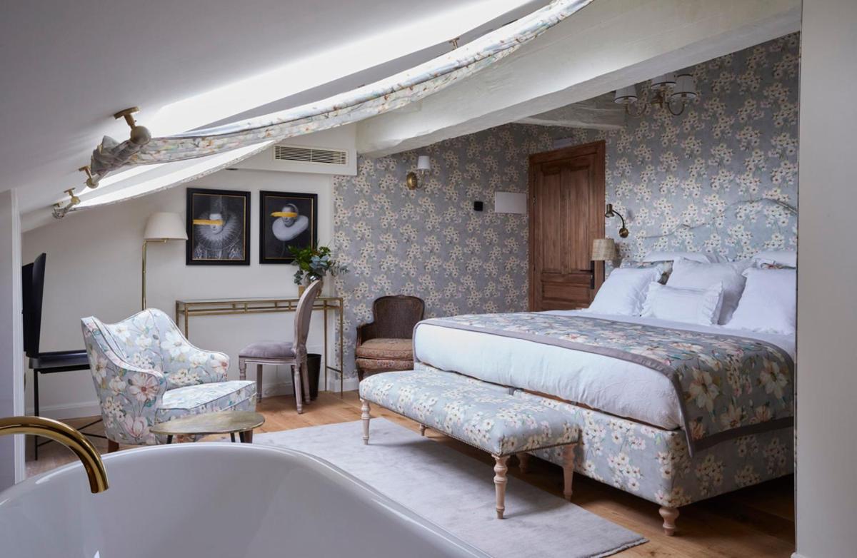 un dormitorio con una cama y una bañera en Helguera Palacio Boutique & Antique, en Torrelavega