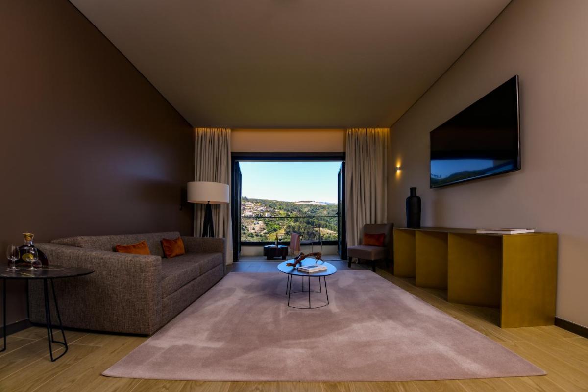 uma sala de estar com um sofá e uma janela grande em MW Douro Wine & Spa em Santa Marta de Penaguião