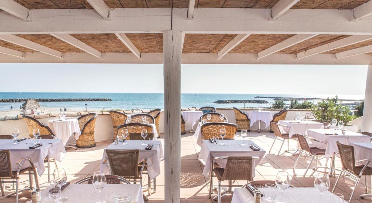un restaurant sur la plage avec tables et chaises dans l'établissement Thalacap Camargue, à Saintes-Maries-de-la-Mer