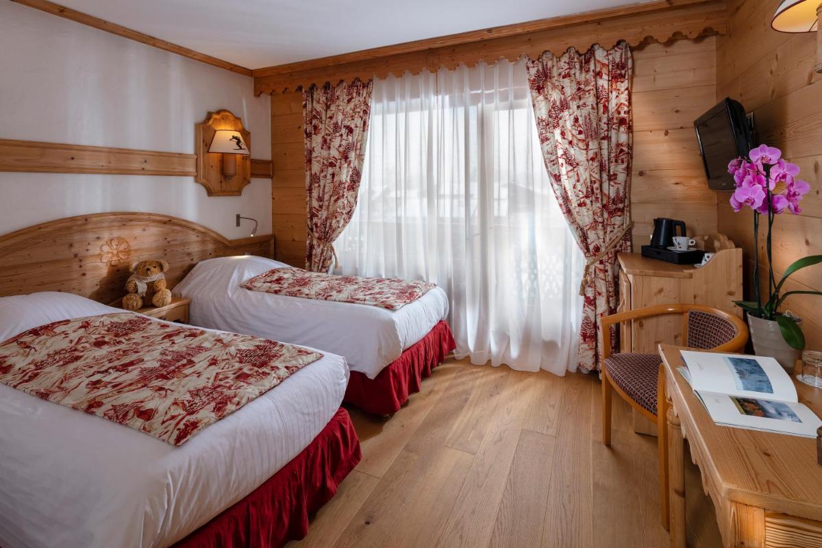 Un ou plusieurs lits dans un hébergement de l'établissement Chalet-Hôtel Neige et Roc, The Originals Relais