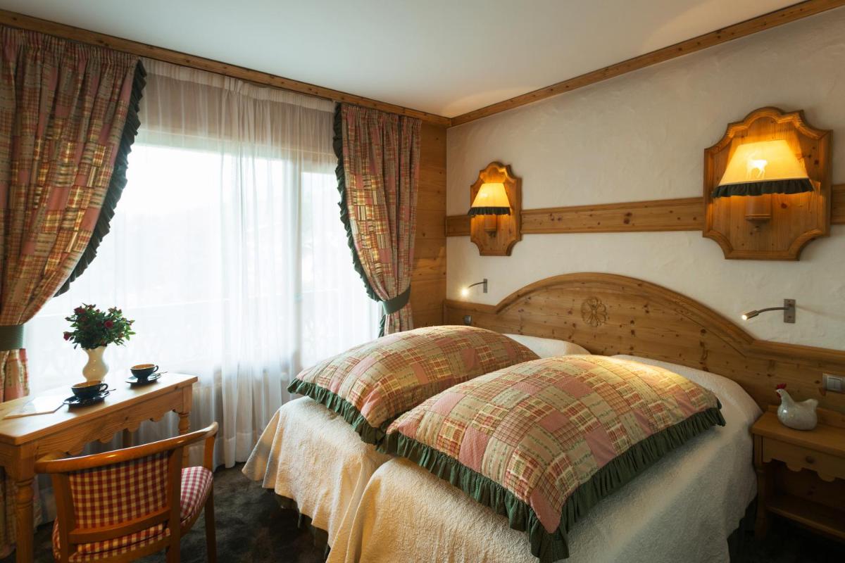 Un ou plusieurs lits dans un hébergement de l'établissement Chalet-Hôtel Neige et Roc, The Originals Relais