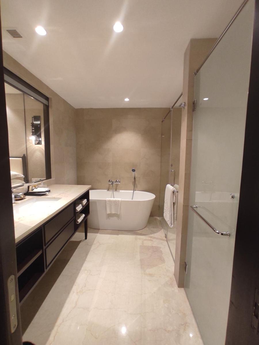 a bathroom with a tub and a sink and a shower at Taj Tirupati in Tirupati