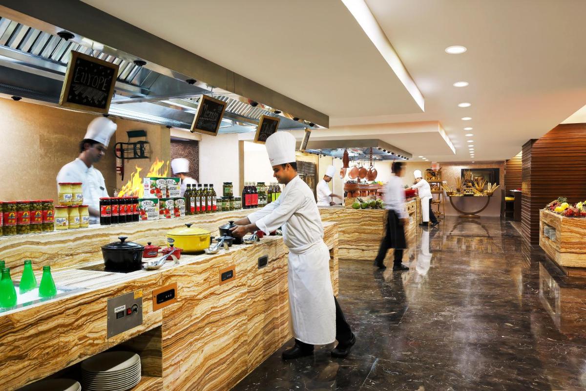 a group of chefs preparing food in a kitchen at Crowne Plaza Ahmedabad City Centre by IHG in Ahmedabad