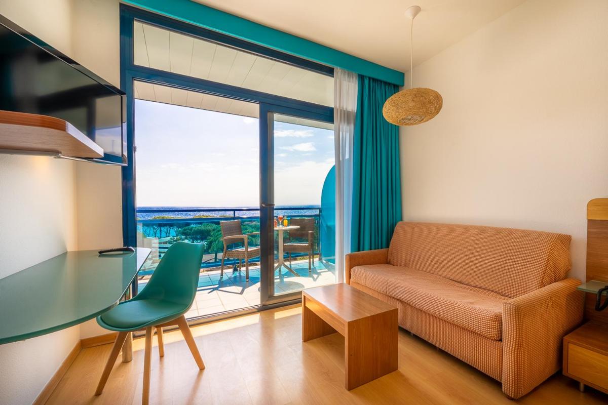 Una sala de estar con un sofá y una mesa de cristal. en Hotel Blaucel, en Blanes