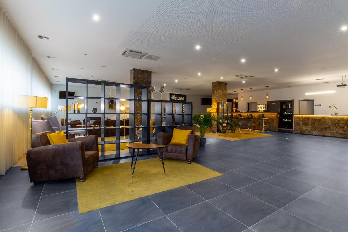 um saguão com sofás, cadeiras e uma mesa em In Gold Hotel & Spa em Águeda mais 65 fotografias