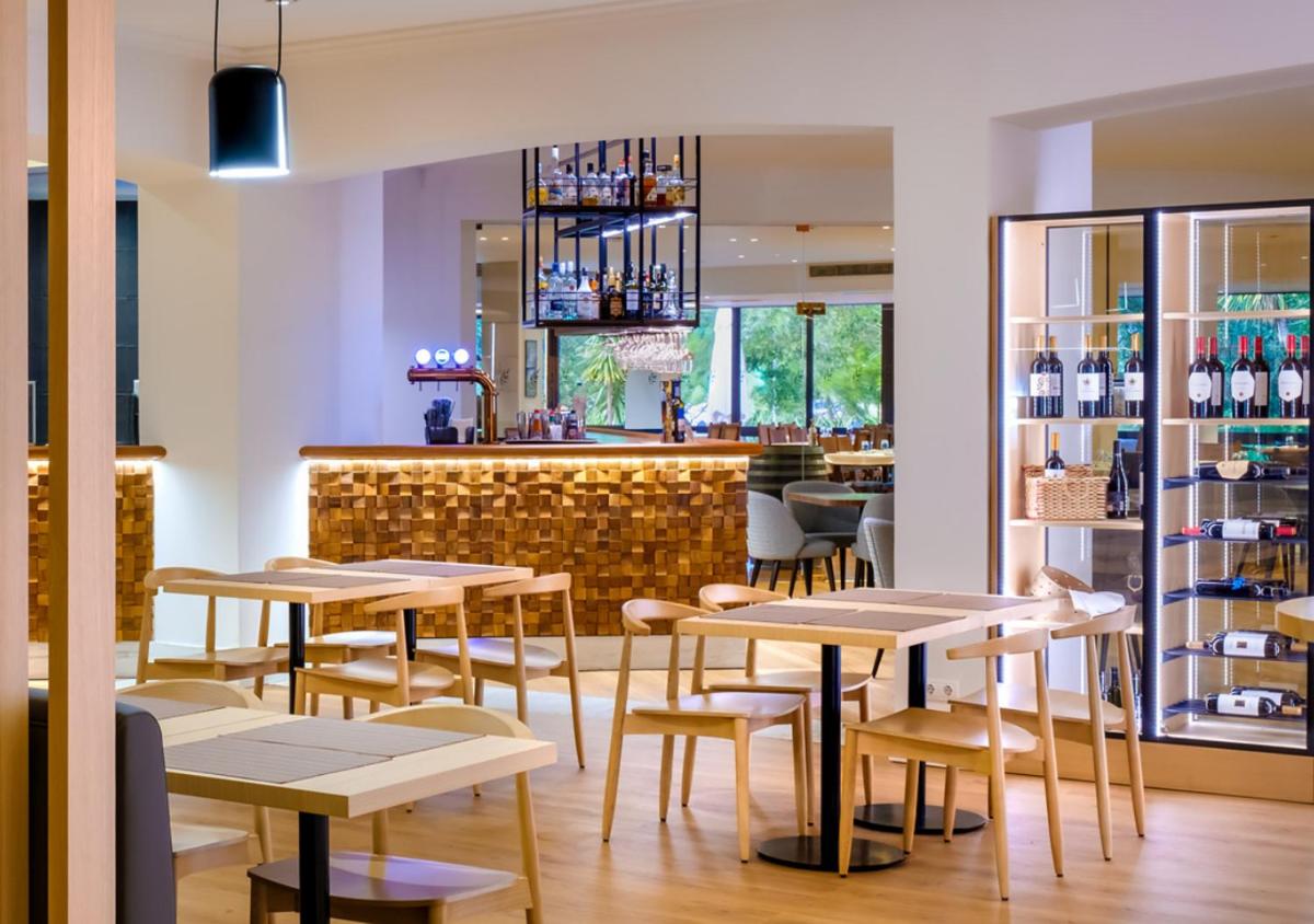 um restaurante com mesas e um bar em Evora Hotel em Évora