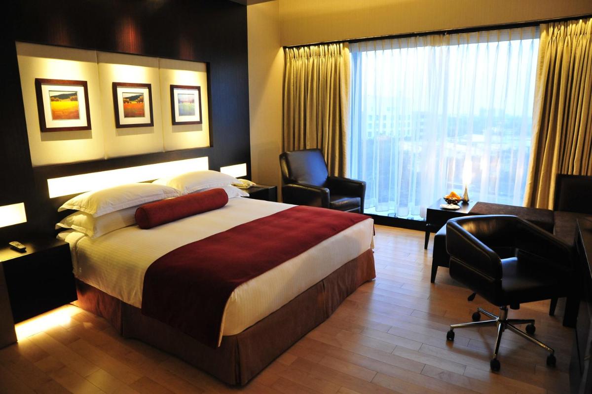 a hotel room with a bed and a desk and chair at The Oterra in Bengaluru