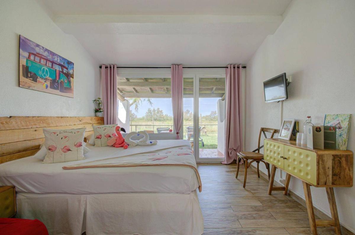 une chambre avec deux lits et une fenêtre dans l'établissement Hôtel La Palunette, à Saintes-Maries-de-la-Mer