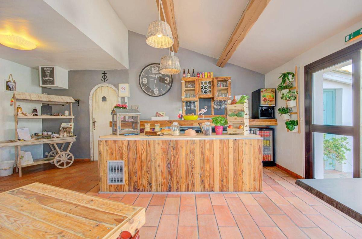 - une cuisine avec un îlot en bois dans l'établissement Hôtel La Palunette, à Saintes-Maries-de-la-Mer