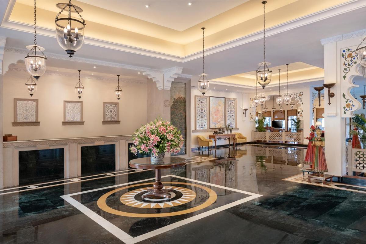 a lobby with a table and a fireplace at Trident Udaipur in Udaipur