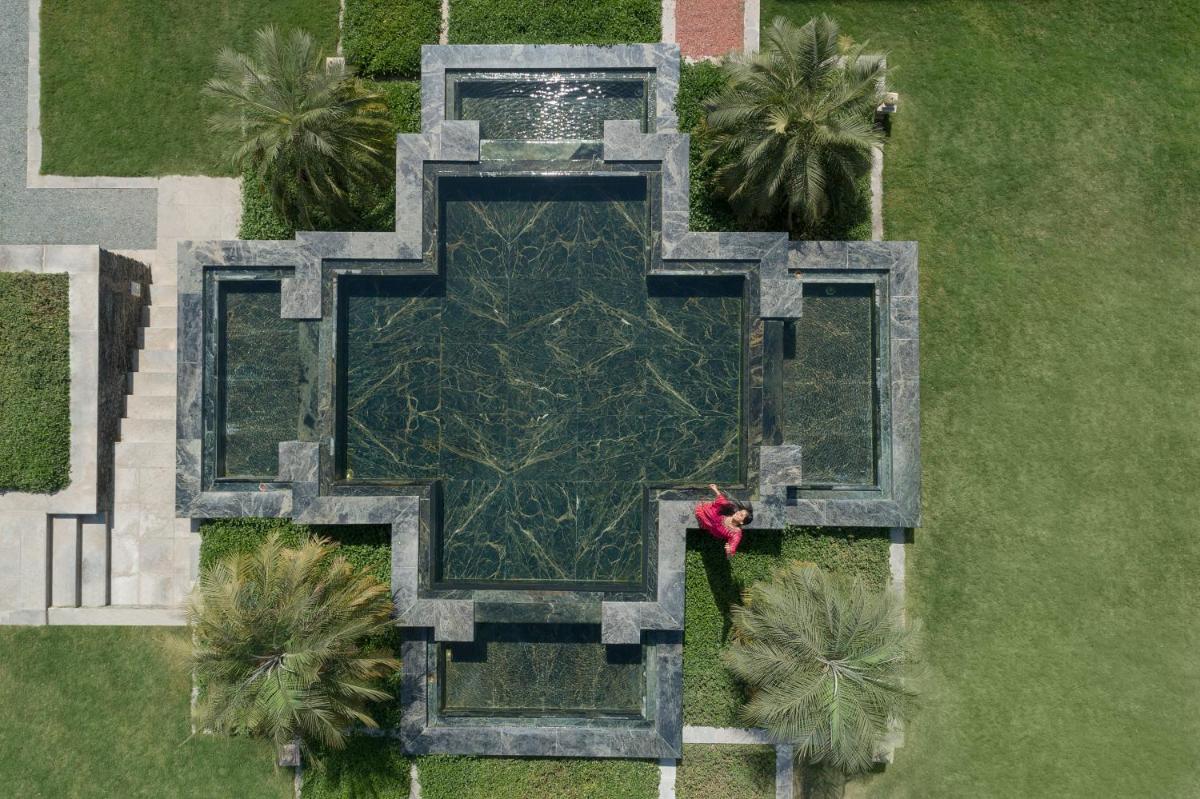 an overhead view of a fountain in a park with palm trees at Trident Udaipur in Udaipur