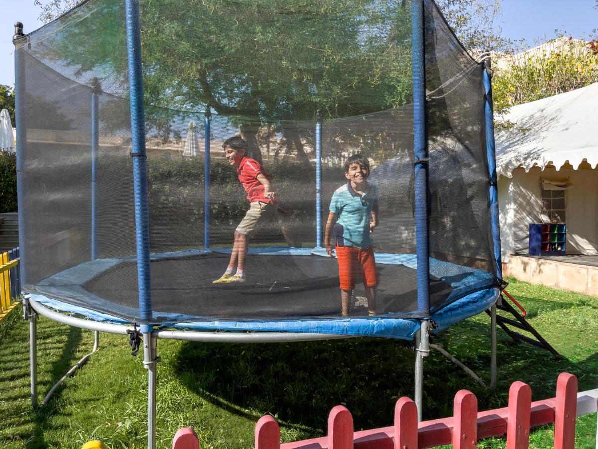 two children are playing on a trampoline at Trident Udaipur in Udaipur