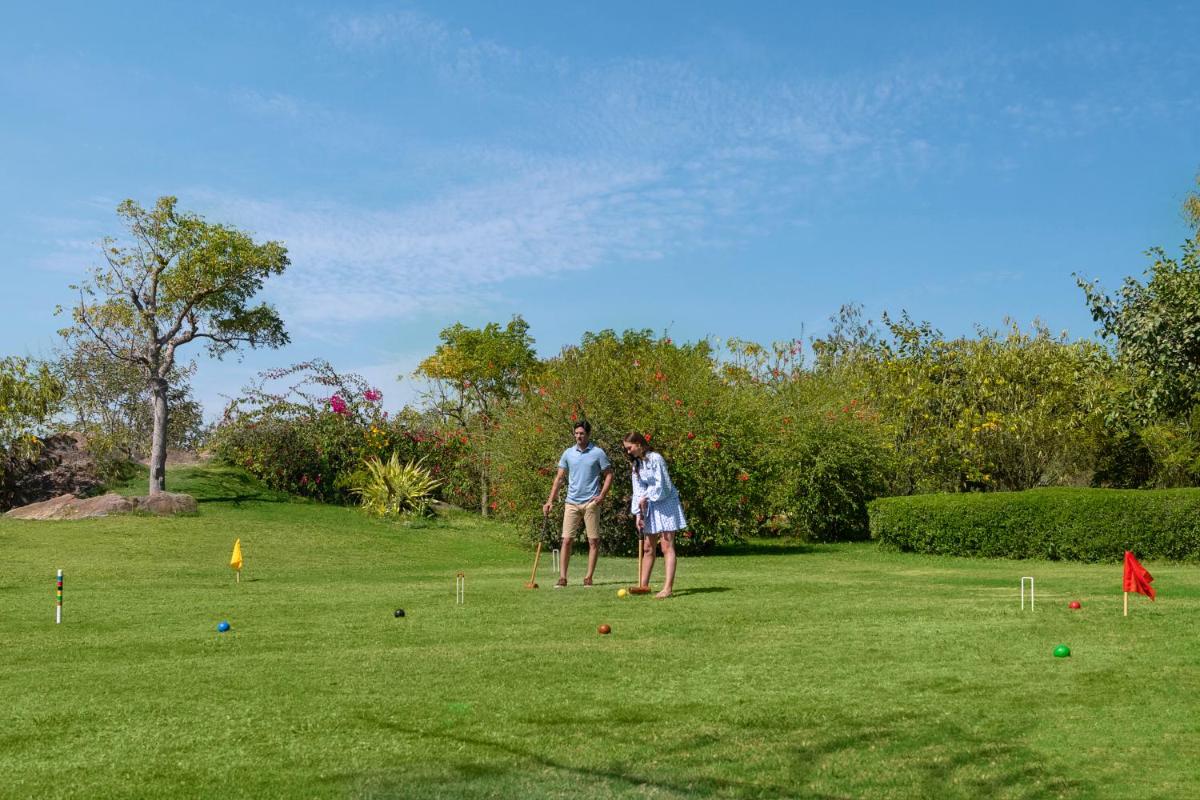 two people playing a game of croquet in a field at Trident Udaipur in Udaipur