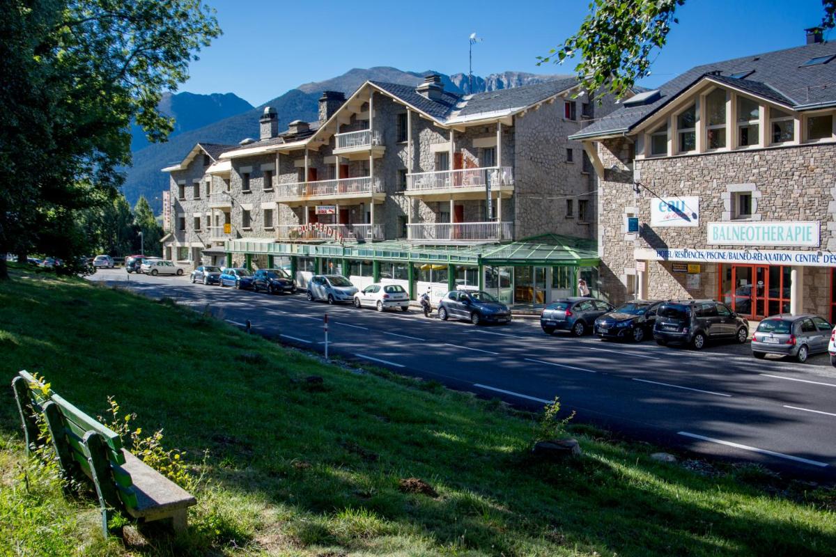 une rue avec des voitures garées sur le bord de la route dans l'établissement Hotel et Résidence Le Clos Cerdan, à Mont-Louis