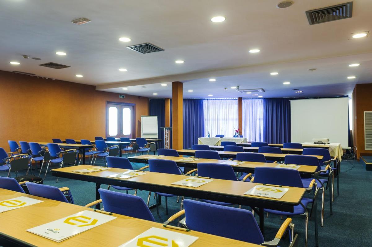Un aula con mesas y sillas en una habitación. en Exagon Park, en Can Picafort 42 fotos más