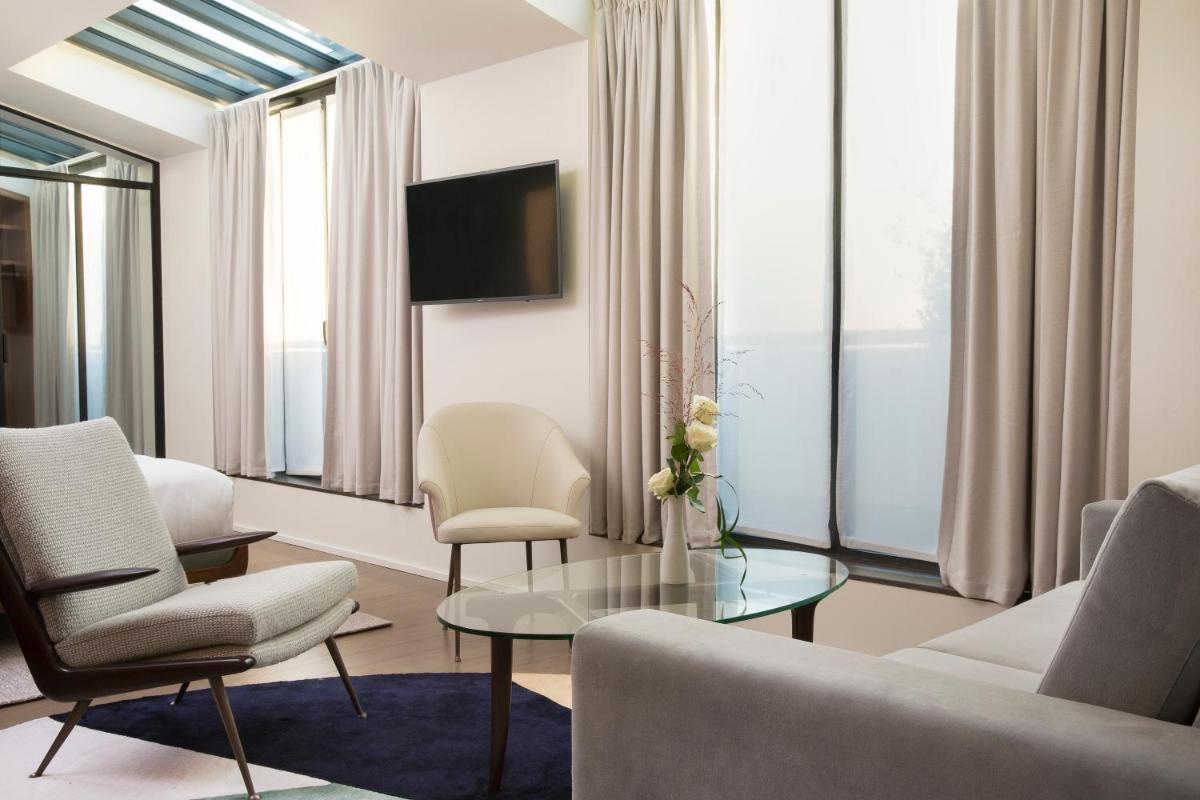 un salon avec un canapé, des fauteuils et une table dans l'établissement Maison Bréguet, à Paris