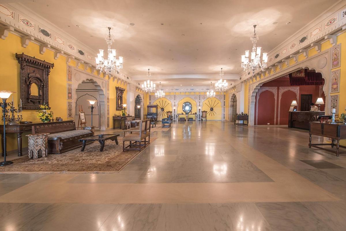 a large room with yellow walls and chandeliers at Fairmont Jaipur in Jaipur
