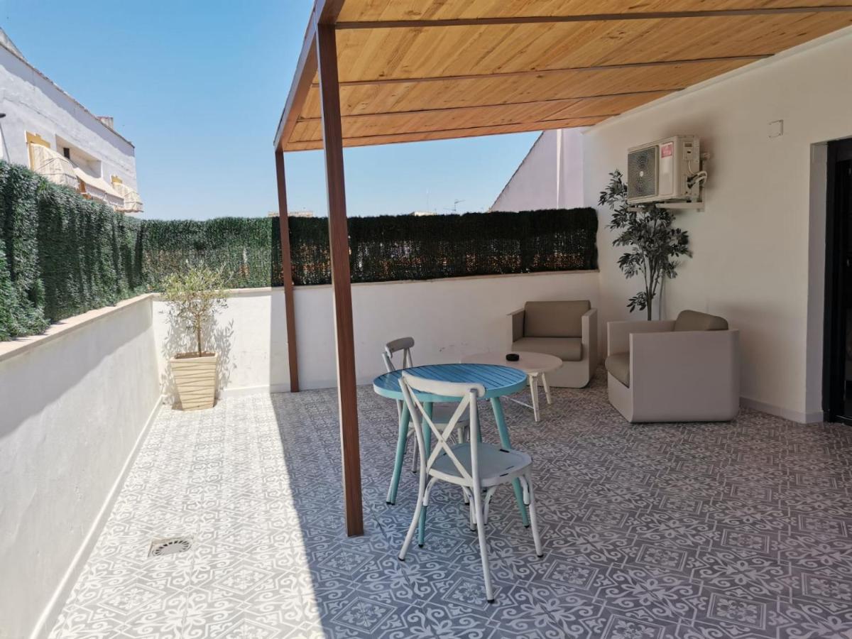 un patio con una mesa y sillas azules y un sofá en Akla Hotel Mérida, en Mérida