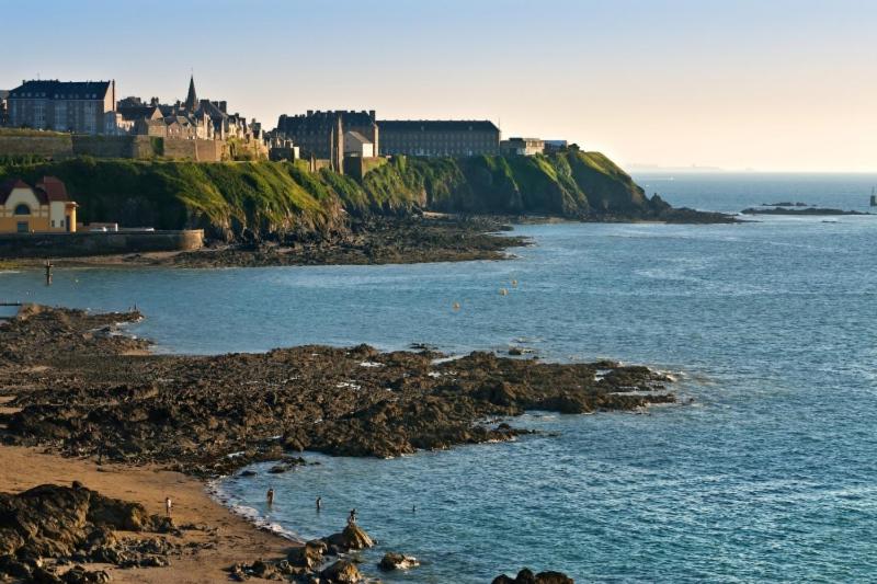 un château au sommet d'une falaise au-dessus d'une étendue d'eau dans l'établissement Ermitage - Mont-Saint-Michel, à Beauvoir