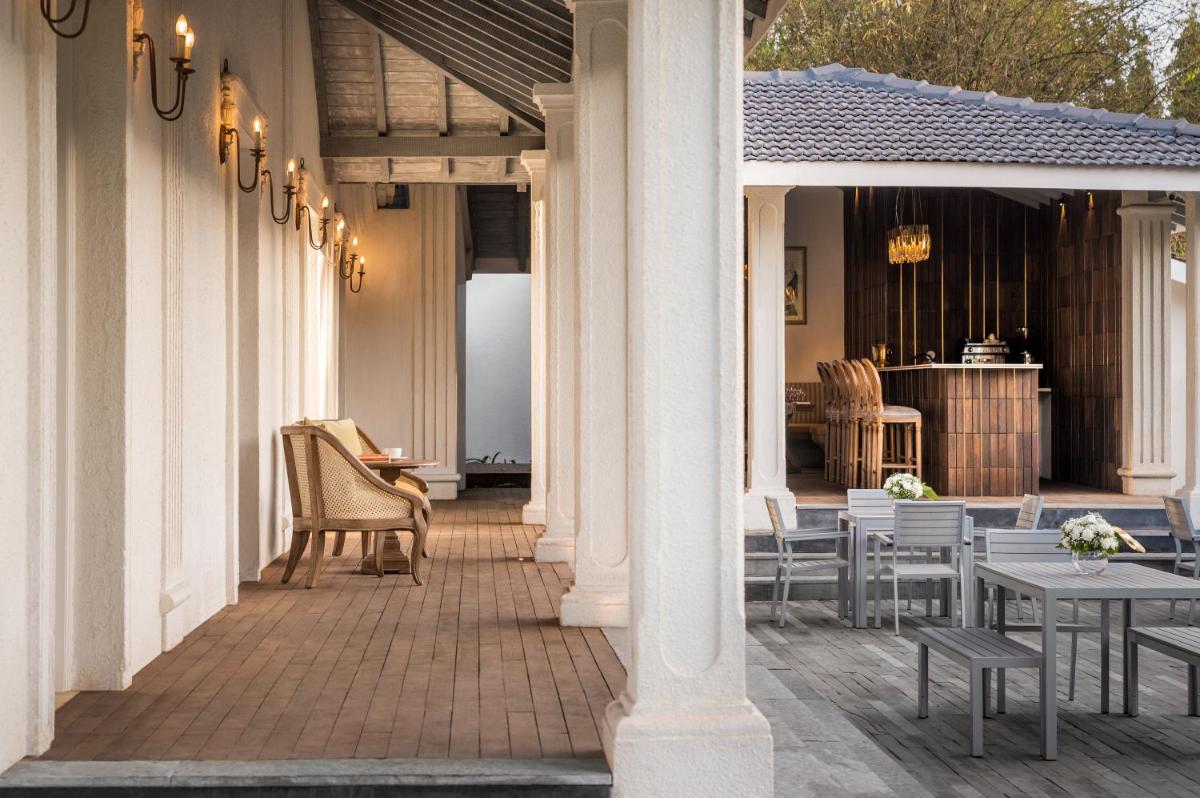 a patio with tables and chairs on a house at MansionHaus in Anjuna