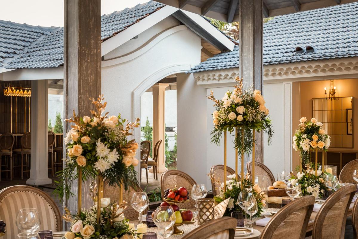 a table set up for a wedding reception with flowers at MansionHaus in Anjuna