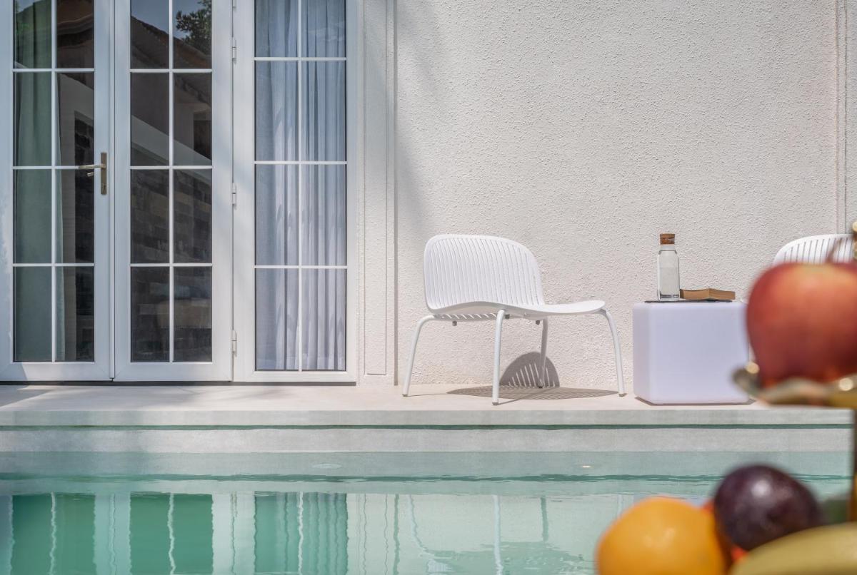 a white chair sitting on a porch next to a pool at MansionHaus in Anjuna