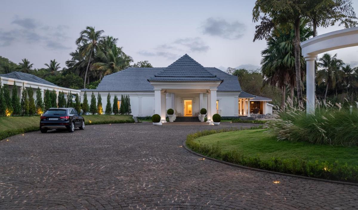 a house with a car parked in the driveway at MansionHaus in Anjuna