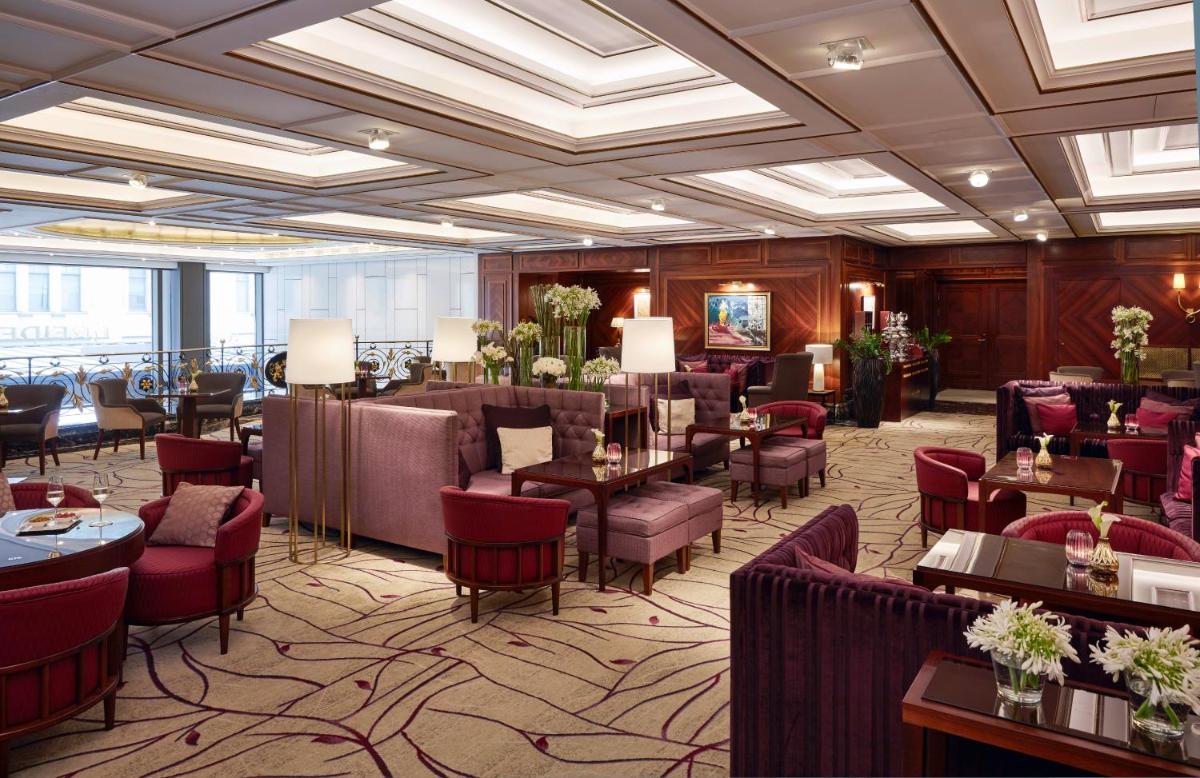 ein Restaurant mit roten Stühlen und Tischen in einem Raum in der Unterkunft Breidenbacher Hof, Best Grandhotel 2025 - Die 101 Besten in Düsseldorf