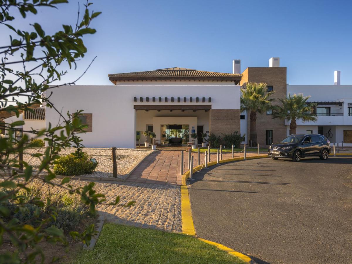 un coche aparcado delante de un edificio en Hotel Fuerte El Rompido, en El Rompido