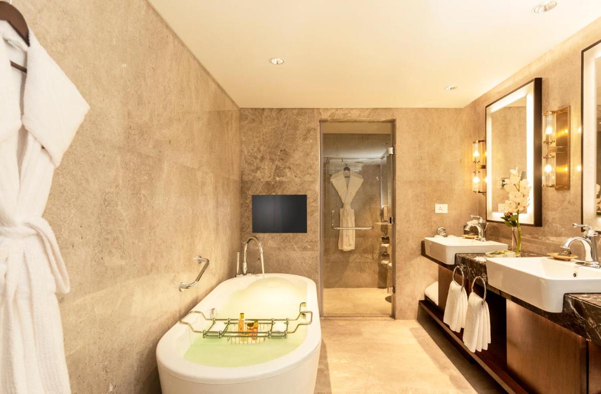a bathroom with a tub and two sinks and a shower at Taj Coromandel in Chennai