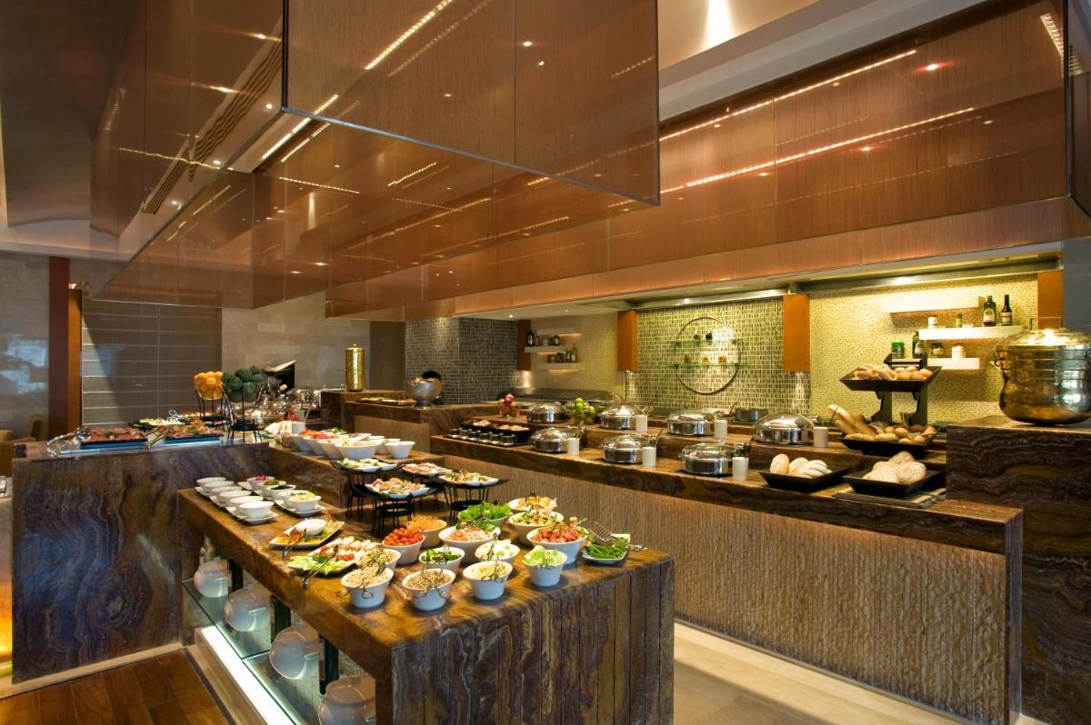 a buffet line in a restaurant with food on display at Taj Coromandel in Chennai