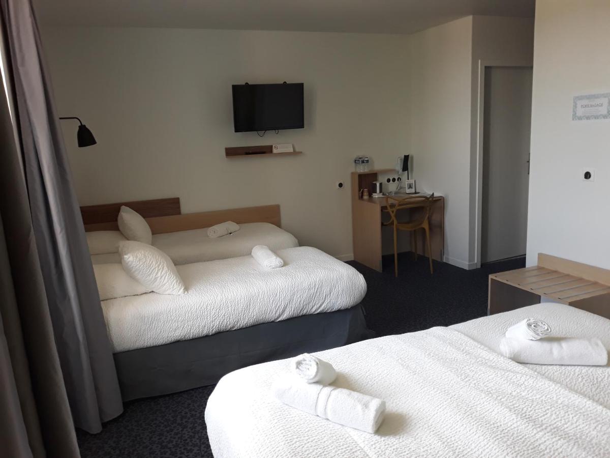 une chambre d'hôtel avec deux lits et une télévision dans l'établissement Le Felicien, à Saint-Félicien