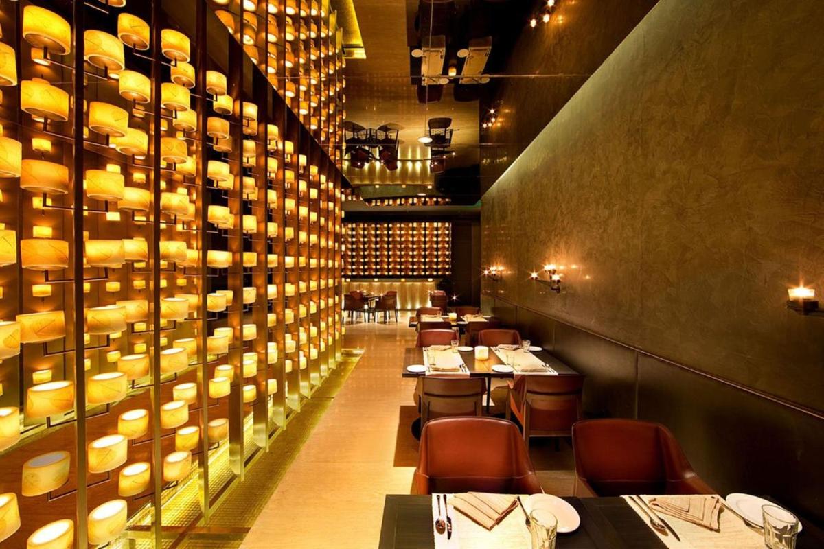 a dining room with tables and plates on the wall at Welcomhotel by ITC Hotels, Dwarka, New Delhi in New Delhi a dining room with tables and plates on the wall at Welcomhotel by ITC Hotels, Dwarka, New Delhi in New Delhi