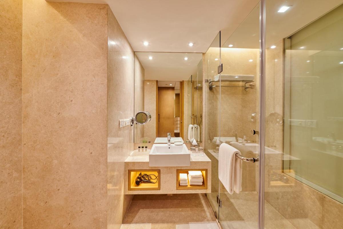 a bathroom with a sink and a shower at Holiday Inn Mumbai International Airport by IHG in Mumbai