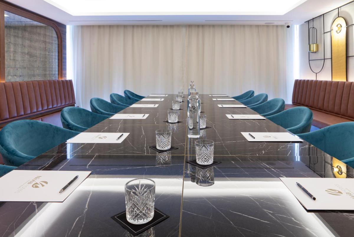 Una sala de conferencias con una mesa larga y sillas azules. en Nivia Born Boutique Hotel, en Palma de Mallorca
