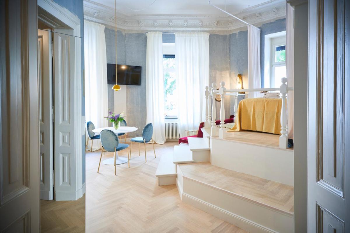 ein Zimmer mit einem Bett und einem Tisch und Stühlen in der Unterkunft Cora Apartments in Leipzig