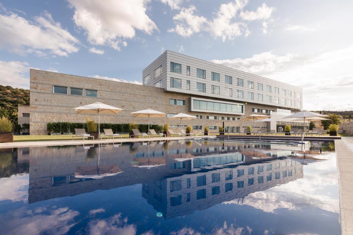 un edificio con piscina en frente de un edificio en Valbusenda Hotel Bodega & Spa, en Toro