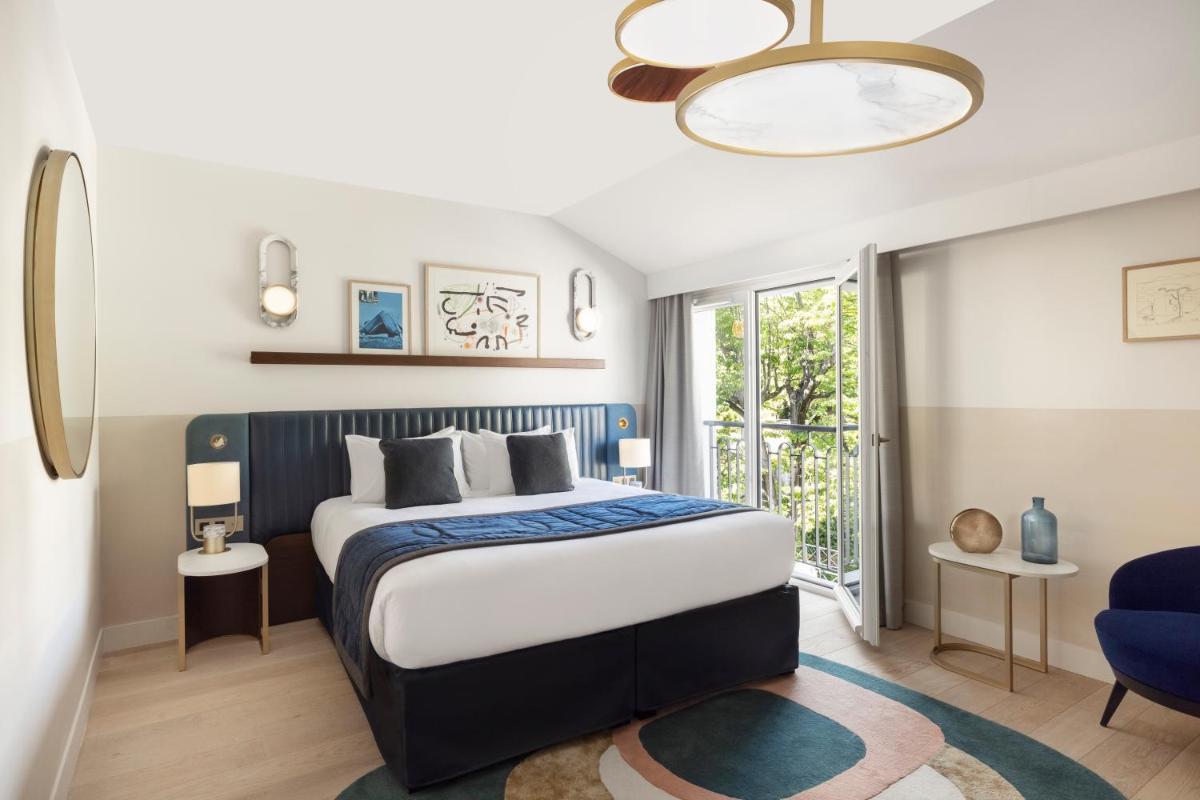 une chambre avec un lit king size et une chaise bleue dans l'établissement Maison Albar Hotels L’Imperator, à Nîmes 128 autres photos