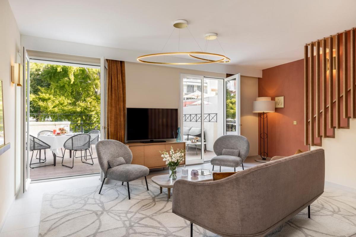 un salon avec un canapé, des chaises et une télévision dans l'établissement Maison Albar Hotels L’Imperator, à Nîmes