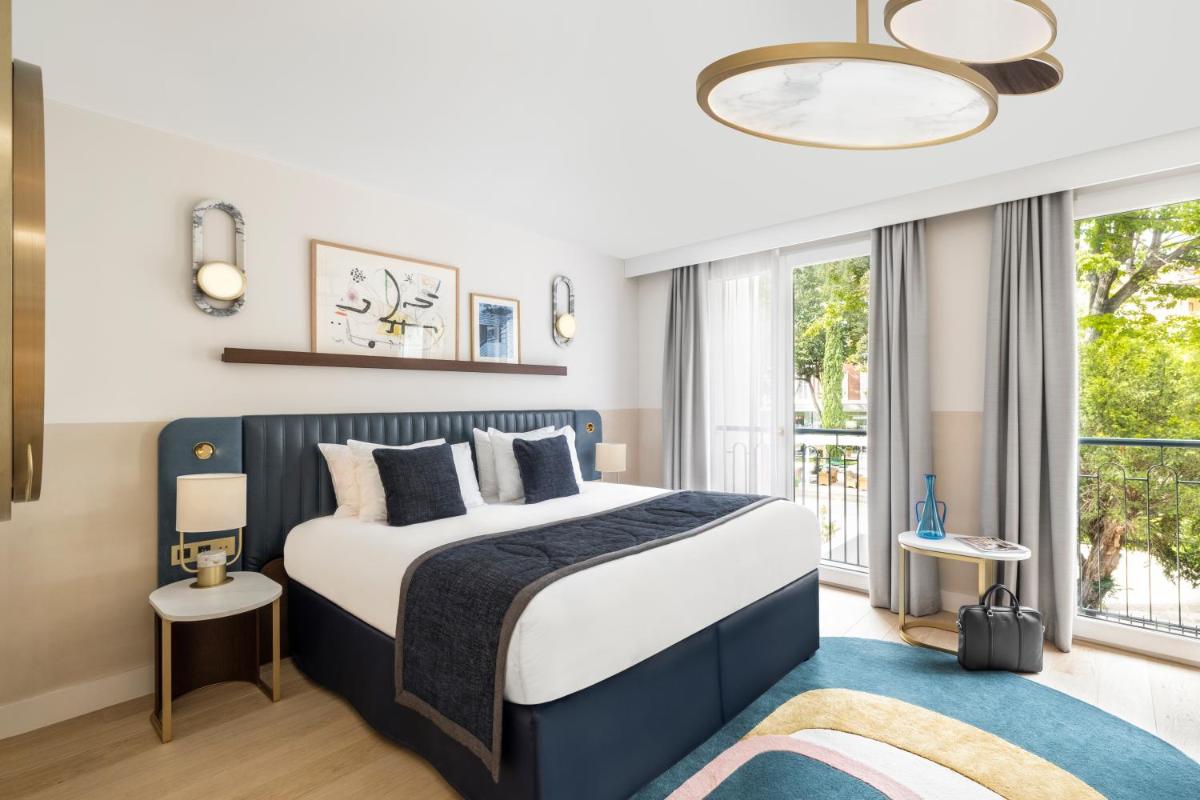 une chambre avec un lit et une grande fenêtre dans l'établissement Maison Albar Hotels L’Imperator, à Nîmes
