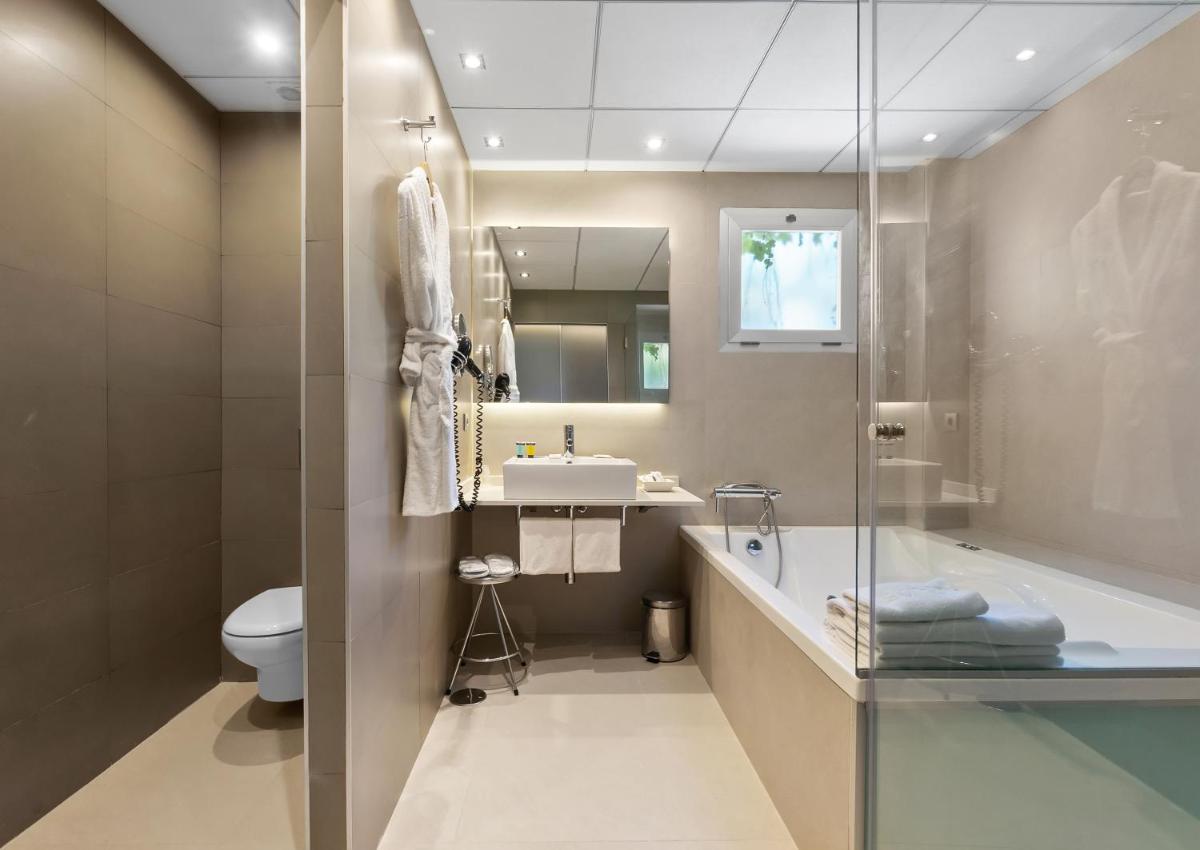 Un baño con bañera, lavabo e inodoro. en Hotel Areca, en Torrellano