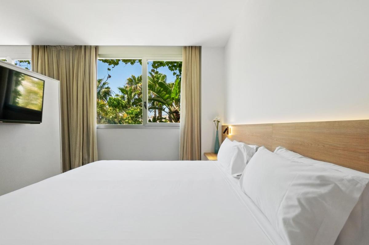 Un dormitorio blanco con una cama grande y una ventana. en Hotel Areca, en Torrellano