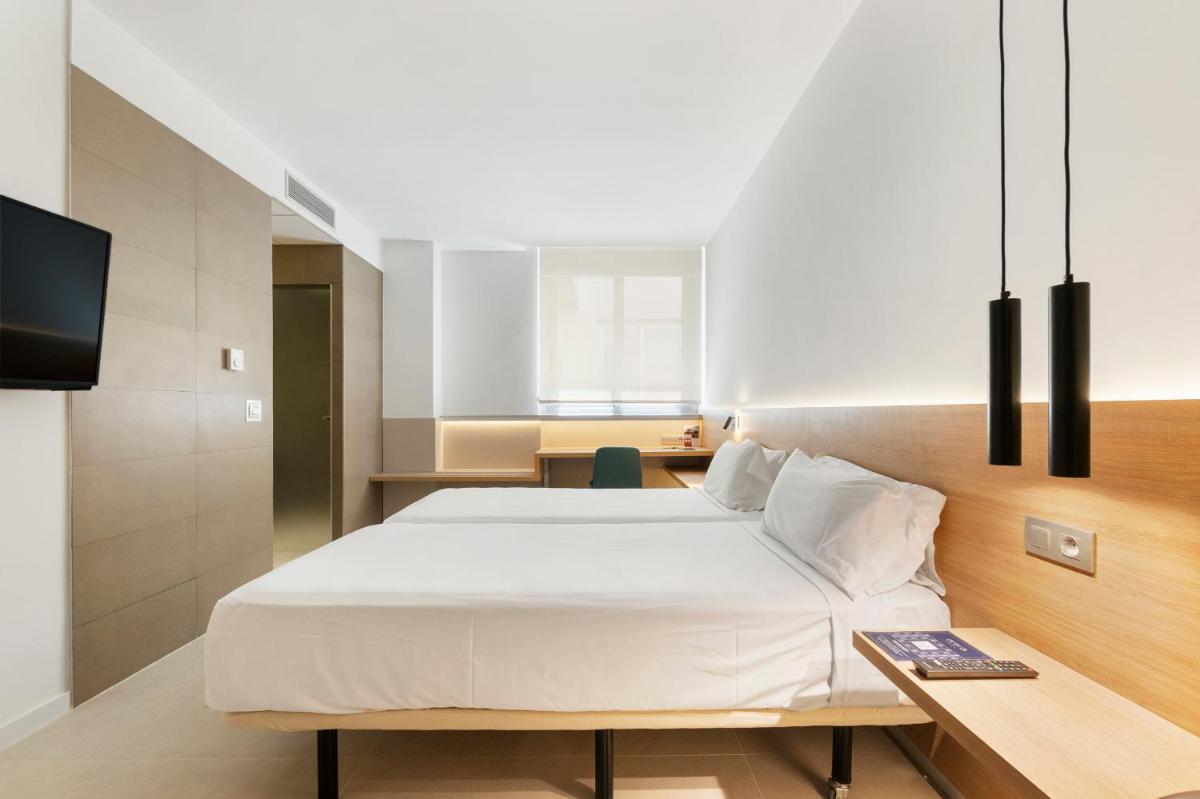Un dormitorio con una gran cama blanca y un escritorio. en Hotel Areca, en Torrellano 50 fotos más