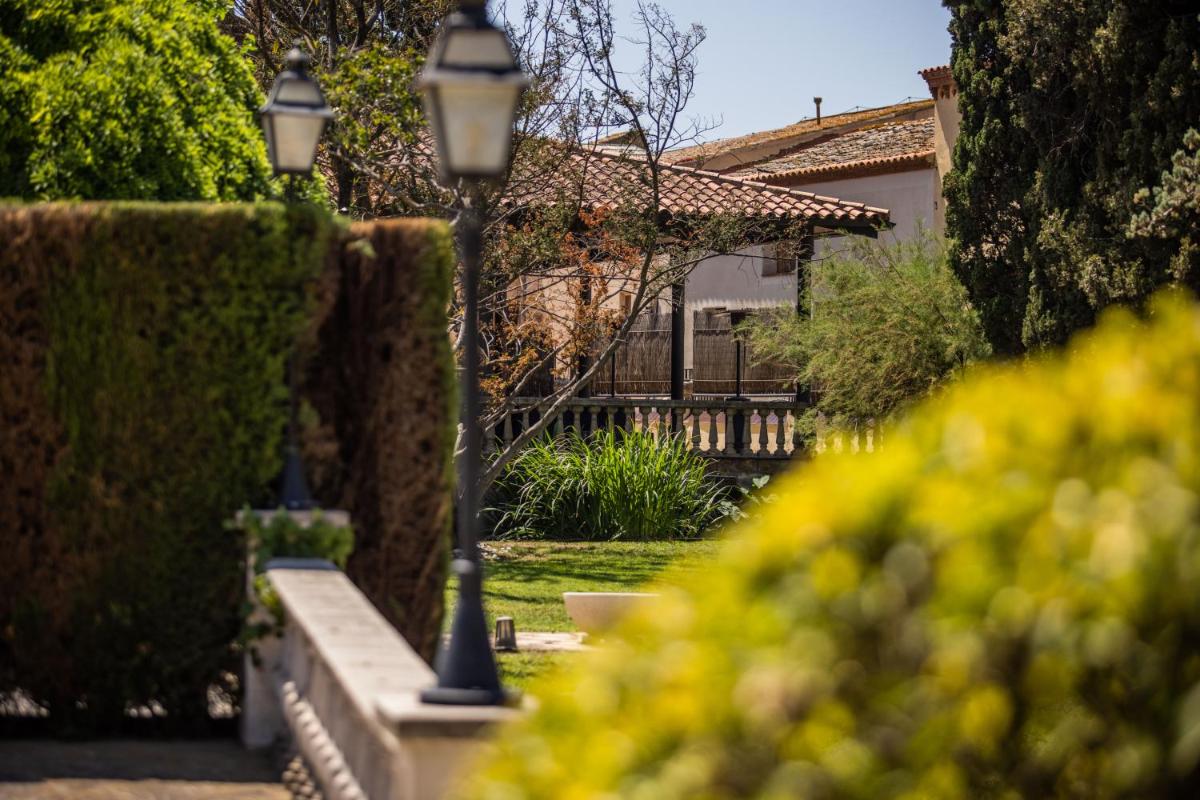 una luz de la calle en un jardín junto a un seto en RVHotels Broquetas Spa Termal, en Caldes de Montbui