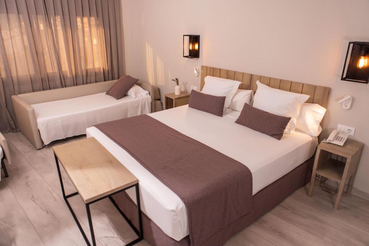 Una habitación de hotel con una cama grande y un sofá. en RVHotels Broquetas Spa Termal, en Caldes de Montbui 40 fotos más