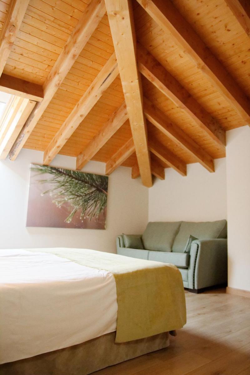 un dormitorio con una cama y un sofá en Hotel Rural Las Montañas de Pumar, en Besullo