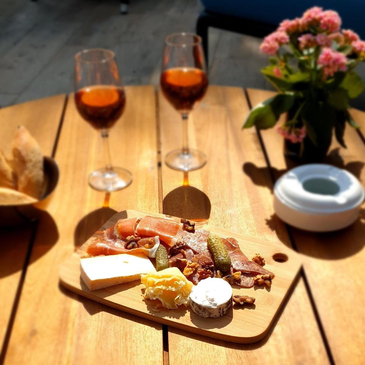 une assiette de nourriture sur une table avec des verres à vin dans l'établissement Le M & Spa Bordeaux Aéroport by Hôtels & Préférence, à Mérignac